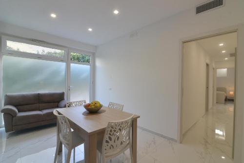 a living room with a table and chairs and a couch at Central Apartment in Matera