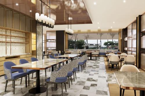 a rendering of a restaurant with tables and chairs at Sheraton Jakarta Soekarno Hatta Airport in Tangerang