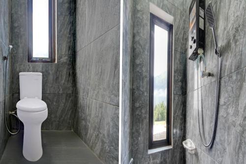 a bathroom with a toilet and a shower at Hotel O Guesthouse Sabar Makmur Kledung Syariah in Temanggung