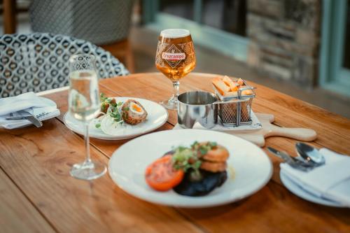 a wooden table with plates of food and a glass of wine at Black Horse Beamish in Stanley