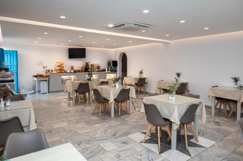 a restaurant with tables and chairs and a kitchen at Perissa Bay in Perissa