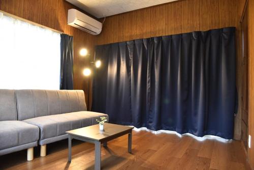 a living room with a couch and a table at 内竈ひなた庵 in Kamegawa
