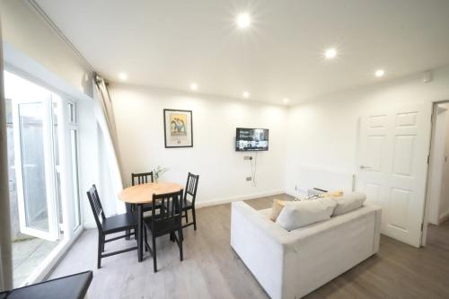 a living room with a white couch and a table at Hatton apartments HEATHROW AIRPORT- FREE parking-Free underground to and from Heathrow Airport Hatton Cross SEE picture-SEE LONDON fast Hatton cross to central London 30min in London