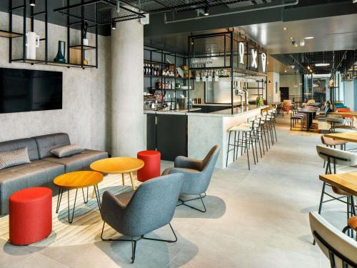 a restaurant with tables and chairs and a bar at Aparthotel Adagio London Sutton Point in Sutton