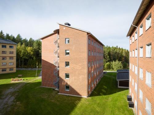 an external view of a brick building with a yard at Guestly Homes - Cozy Studio in Luleå