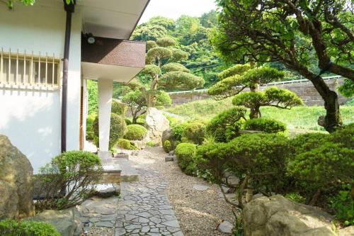 a garden with a stone path next to a house at 内竈ひなた庵 in Kamegawa