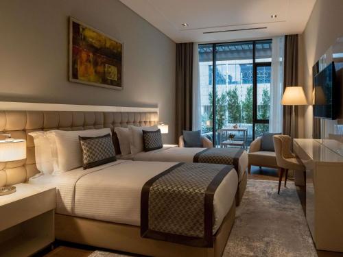a hotel room with a large bed and a desk at Movenpick Living Istanbul West in Istanbul