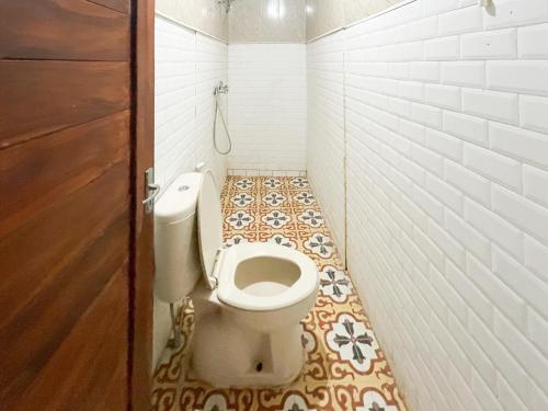a small bathroom with a toilet in a stall at RedDoorz at Villa Krisna Balangan Beach in Jimbaran