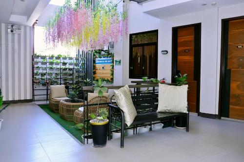a lobby with a bench and chairs and a chandelier at Dachannry's Place Hotel in Cagayan de Oro