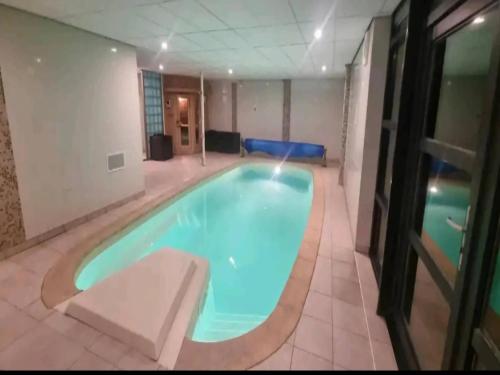 Chalet in Odeigne with Private Pool & Sauna في Manhay: حمام سباحة كبير في غرفة في الفندق مع