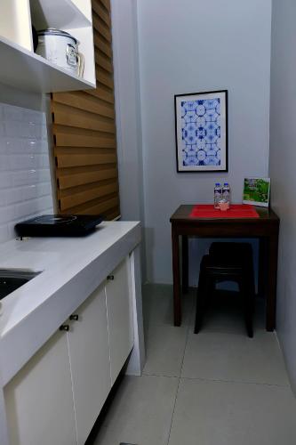 a kitchen with a table and a small table with a stool at Dachannry's Place Hotel in Cagayan de Oro