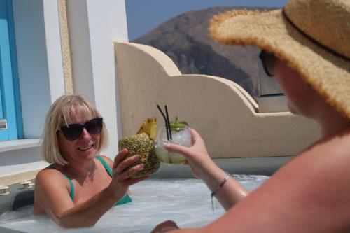 two women sitting in a hot tub with a drink at Perissa Bay in Perissa