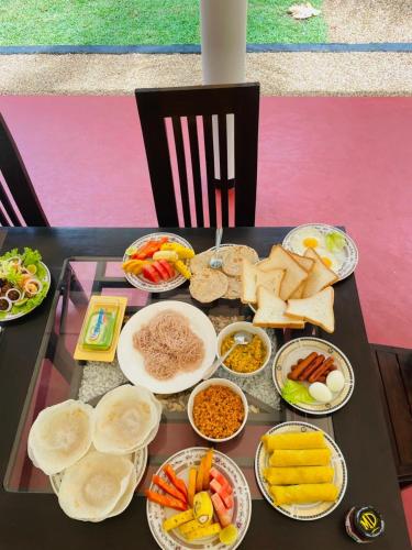 una mesa con diferentes tipos de alimentos. en Dedunu Resort & Yala Safari, en Tissamaharama