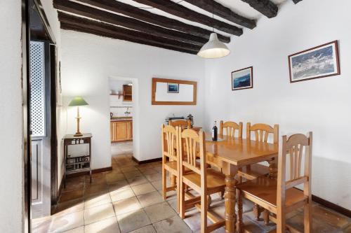 a dining room with a wooden table and chairs at Casa Rural El Palmar in Vallehermoso