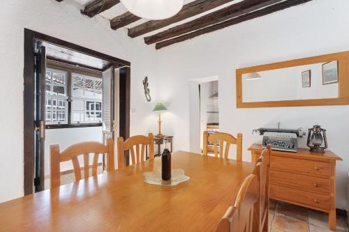 a dining room with a wooden table and chairs at Casa Rural El Palmar in Vallehermoso