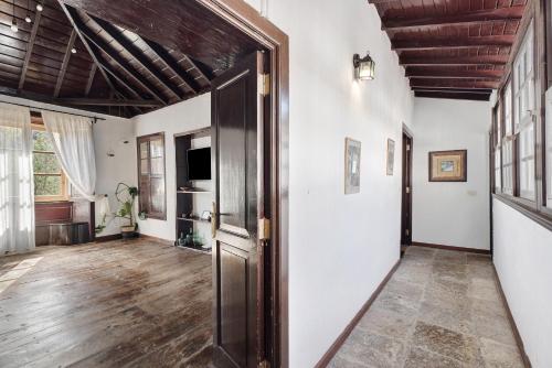 an open door in a room with white walls and wooden ceilings at Casa Rural El Palmar in Vallehermoso
