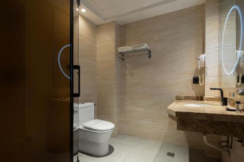 a bathroom with a toilet and a sink at Tongren Golden Beach Hotel in Tongren