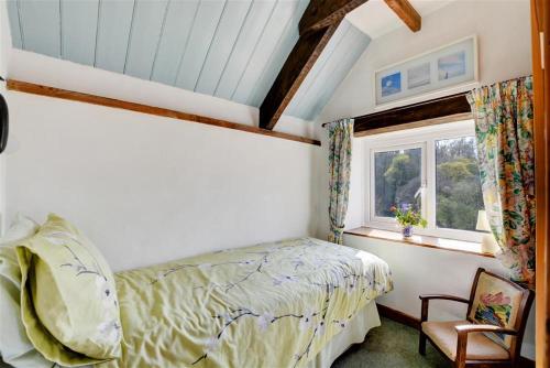 a bedroom with a bed and a window and a chair at The Stables in Whitland