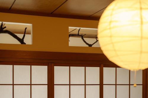 a white lantern hanging from a ceiling next to windows at 内竈ひなた庵 in Kamegawa