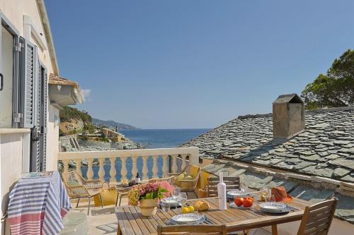 a table on a balcony with a view of the ocean at Casa Di U Mare in San-Martino-di-Lota