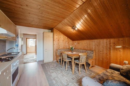 a kitchen and dining room with a wooden ceiling at Ferienwohnungen Knaus in Lam