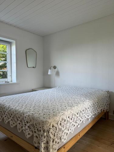 a bedroom with a bed with a white bedspread at Beautiful cottage with ocean view in Esbjerg