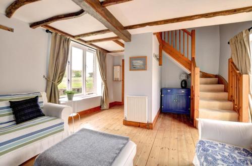 a living room with a staircase and a couch at The Little Barn in Saxlingham