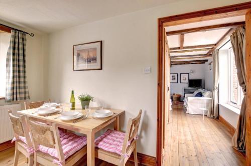 a dining room with a wooden table and chairs at The Little Barn in Saxlingham