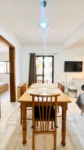 a dining room with a wooden table and chairs at Be Happy Three-Bedroom Apartment in St. Paul's Bay