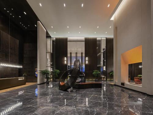 a lobby with a sculpture in the middle of a building at Novotel Xian Xixian in Xi'an