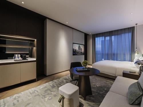 a hotel room with a bed and a table at Novotel Xian Xixian in Xi'an