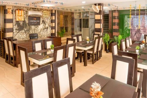 a dining room with tables and chairs in a restaurant at Comfort Stay - Saheed Path Ahimamau, Near Lulu Mall in Lucknow