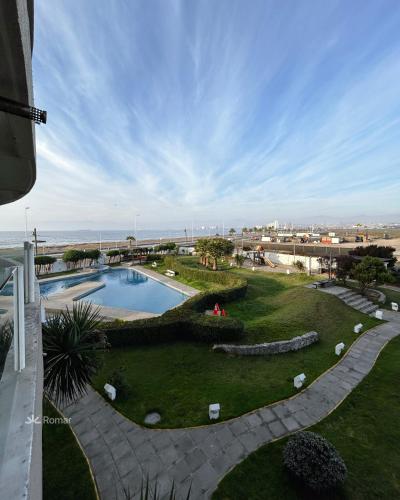 a view of a garden with a swimming pool at Romar Departamentos Vista al Mar Costanera in Coquimbo