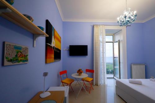 a blue living room with a table and chairs at Mare Magnum in Castellammare di Stabia