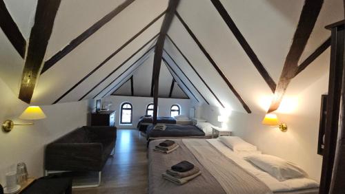 a attic room with a bed and a couch at Villa Podkarpacka in Kudowa-Zdrój