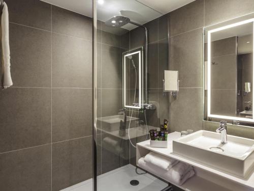 a bathroom with a sink and a shower at Novotel Cambridge North in Cambridge