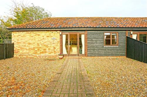 a small house with a brick driveway in front of it at The Stables in Wangford
