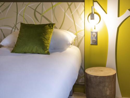 a bedroom with a bed with a pillow and a lamp at ibis Styles Contres-Cheverny in Le Controis En Sologne
