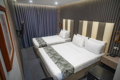 a bedroom with two beds with white sheets and pillows at Perc Hotel in Pinamungahan