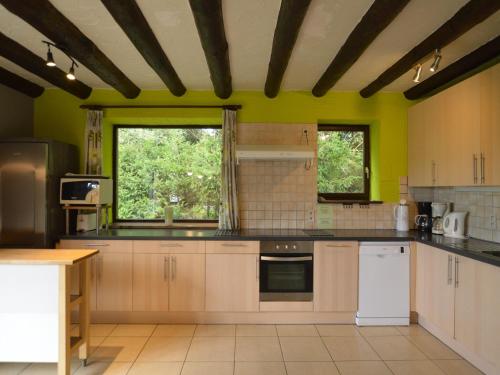 a kitchen with white appliances and yellow walls at Elegant Bevercé Escape in Malmedy
