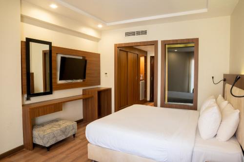 a hotel room with a bed and a television at Rivoli Suites in Hurghada