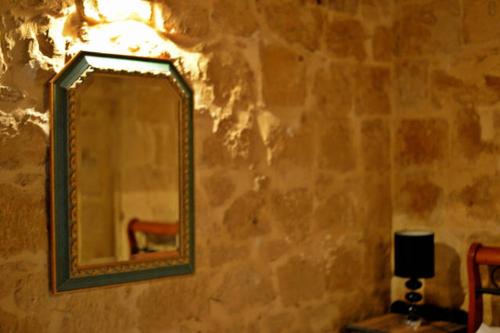 a mirror on a wall with a lamp and a chair at Vallettastay City break apartments in Valletta