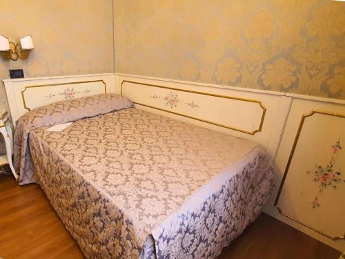 two twin beds in a room with a wall at Hotel Carlton On The Grand Canal in Venice