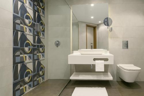 a bathroom with a sink and a toilet at Phoenix Hotel & Wellness in Sheikh Zayed