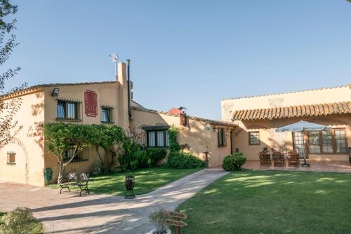 a house with a lawn in front of it at Hotel & Golf Ca La Caputxeta in Castelló d'Empúries