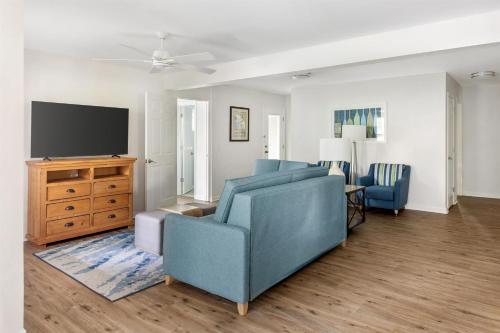 a living room with a blue couch and a tv at Hilton Vacation Club Beachwoods Kitty Hawk in Kitty Hawk