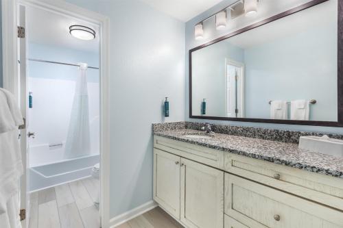 a bathroom with a sink and a large mirror at Hilton Vacation Club Beachwoods Kitty Hawk in Kitty Hawk