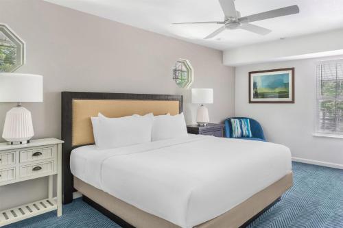 a bedroom with a white bed and a ceiling fan at Hilton Vacation Club Beachwoods Kitty Hawk in Kitty Hawk