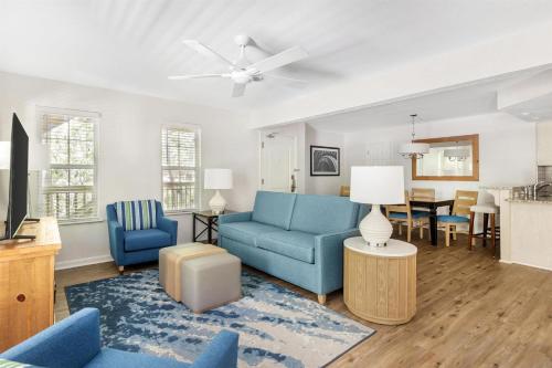 a living room with a blue couch and a table at Hilton Vacation Club Beachwoods Kitty Hawk in Kitty Hawk