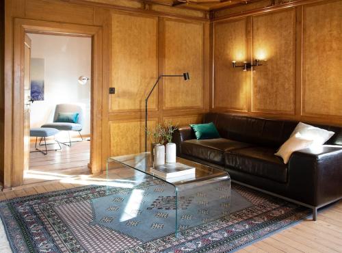 un salon avec un canapé en cuir et une table en verre dans l'établissement Fromm's Guesthouse, à Malans